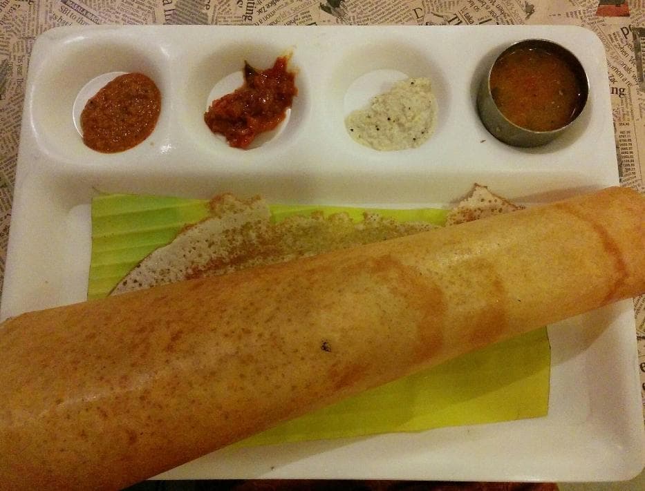 Dosa served with sambar and coconut chutney